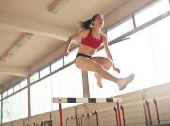 Athletic Woman Jumping Hurdle