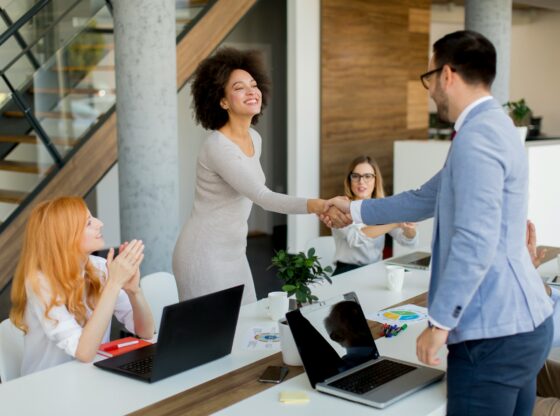 two people shake hands at the end of a business meeting